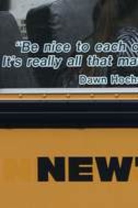 Children sit on a bus adorned with a quote from slain Sandy Hook school principal Dawn Hochsprung.