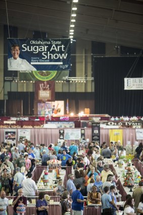 Show time: Crowds admire the "sugar art" at Tulsa, including hamburger cakes and cakes that look like dinosaur sjulls. 