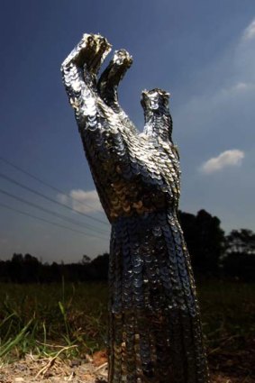 A sequined hand reaches from the ground.