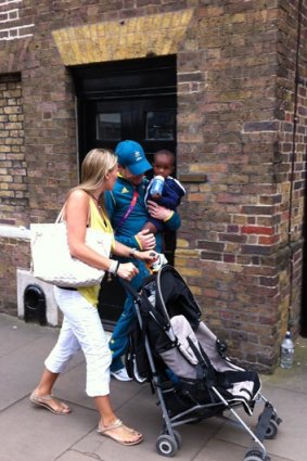 Cadel Evans holds his adoped son, Robel, as he strolls with wife Chiara Passerini after the Olympic men's road race.