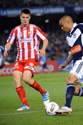 Victory's Archie Thompson takes on Curtis Good in the A-League last season.
