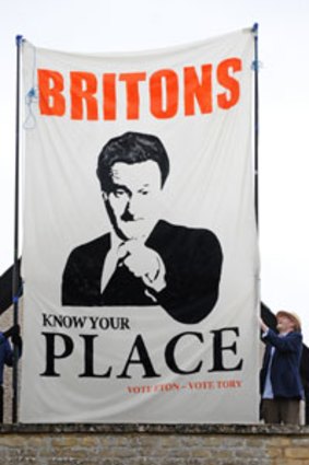 Labor supporters unfurl a banner mocking Conservative leader David Cameron.