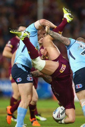 Trent Merrin (L) and Trent Hodkinson (R) of the Blues dump Cameron Smith of the Maroons.