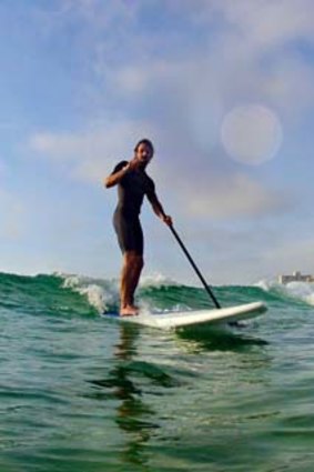 A stand-up paddler takes to the waves.