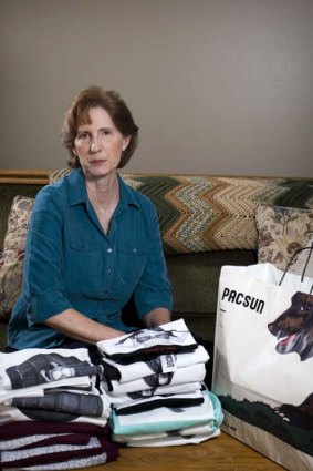Judy Cox sits next to a stack of T-shirts with what she believes are pornographic designs Monday, Feb. 17, 2014, in Orem, Utah.