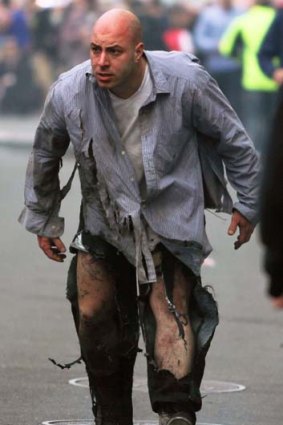 Walking wounded: A shocked victim escapes after two explosions hit the Boston Marathon on Monday.
