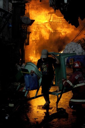 Residents try to save belongings from a fire that engulfed a slum area in Manila on January 1, 2015.