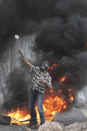 A Palestinian throws a stone during clashes with Israeli soldiers at the Qalandia checkpoint, in the Israeli occupied West Bank.