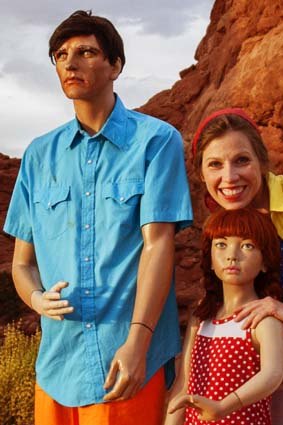 Suzanne Heintz poses for a traditional vacation photo with her artificial family.