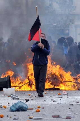 A flag-bearing youth during a protest in Athens last year. Will rising debt cause more unrest?