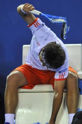 Overhead smash ... Marcos Baghdatis of Cyprus makes light work of his racquet during his defeat to Switzerland's Stanislas Wawrinka.