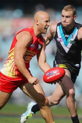 Too quick: Gary Ablett, who was quiet by his standards, beats Port Adelaide's Andrew Moore to the punch.