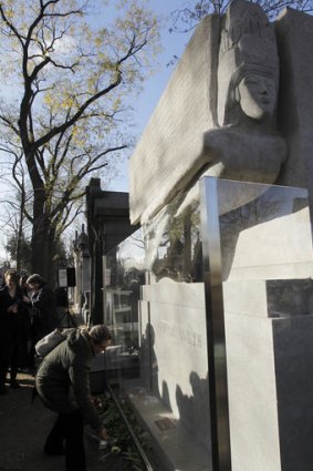 Visitors put flowers on the newly renovated tombstone of Irish writer Oscar Wilde, at the Pere Lachaise cemetery, in Paris.