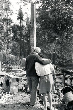 Ruth Rayment is comforted by her brother, Philip, in the remains of their Belgrave home.