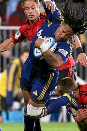 Ma'a Nonu of the Highlanders is tackled by Owen Franks.