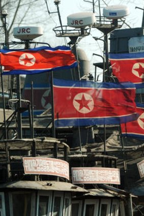 North Korean flags fly at half-mast on fishing boats.