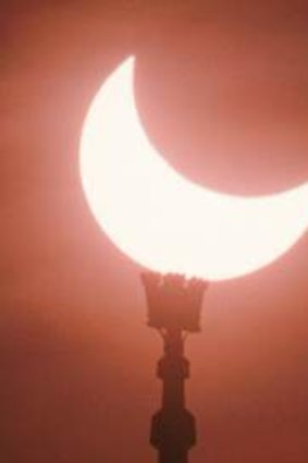 A partial eclipse of the sun over a mosque in Europe.