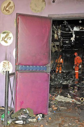 Rescue workers investigate the burnt-out Kiss nightclub in Brazil.