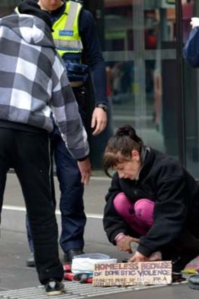 Police check a beggar's bowl in Melbourne on Wednesday.