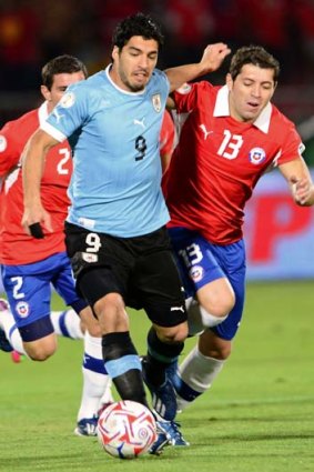 Tussle: Luis Suarez, left, playing for Uruguay against Chile.