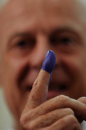 UN special representative for Afghanistan Staffan de Mistura displays an indelible ink mark on his finger used for voting.