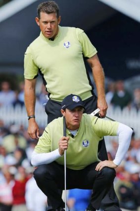 Team Europe golfers Nicolas Colsaerts of Belgium and Lee Westwood of England (top) size up a putt.