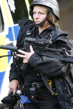 An armed British police officer in Rothbury, England, patrols a street as the manhunt continued for Raoul Moat.