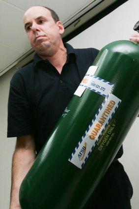 If one green bottle &#x2026; Investigator Neville Blyth shows the oxygen cylinder that was next to the missing one. PICTURE:  AP