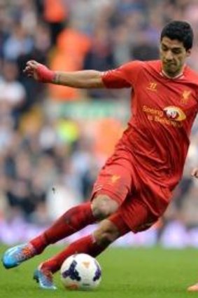 Liverpool's  Luis Suarez, left, takes on Tottenham Hotspur's  Nacer Chadli during Liverpool's 4-0 win.