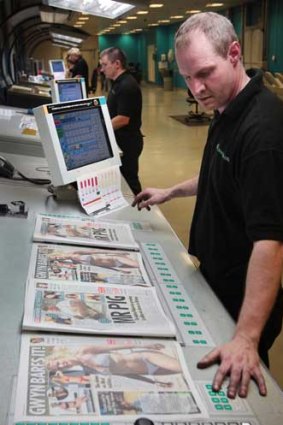 Printer Danny Thompson inspects copies of the last edition of the News of The World.