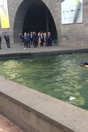 Pedestrians watched in bemusement as the man swam in the NGV moat.