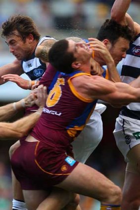 The Brisbane Lions' Jonathan Brown collides with teammate Mitch Clark (right) in a pack in the game against Geelong at the Gabba.