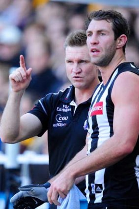 Collingwood coach Nathan Buckley talks to Travis Cloke on the sidelines earlier this year.