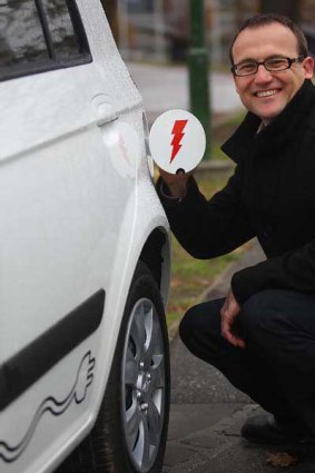 Greens candidate Adam Bandt with an electric car. <i>Photo: Ken Irwin</i>