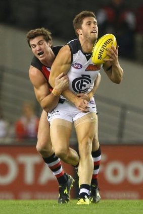 Marc Murphy handballs while being tackled by Lenny Hayes.
