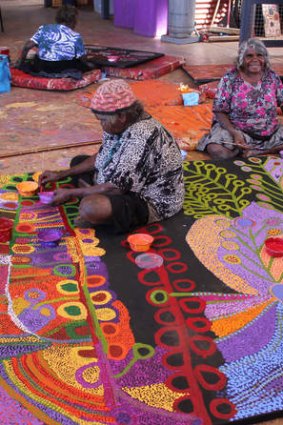 Traditional artists Wawiriya Burton (left) and Ruby Williamson. Artworks from South Australia's Tjala Arts range from traditional styles done in modern colours to more contemporary experimentations.