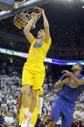 Golden State Warriors guard Klay Thompson slam dunks against Los Angeles Clippers forward Jared Dudley.