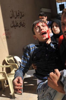 A wounded Syrian boy is carried to hospital after an airstrike by government forces in Maaret al-Numaan.