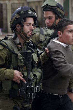 Hebron clash … Israeli soldiers seize a Palestinian boy.