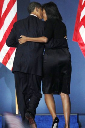 Job done: Barack Obama gets a hug from his wife, Michelle, as he leaves his election night rally.