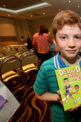 Finn Prendergast, 7, from Taragindi, and Ned Naouri, 7, from Annerley, have their copies of "Deadly D and Justice Jones - Making the Team"