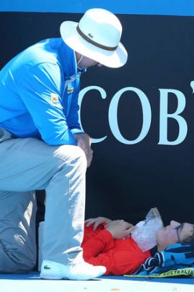 Casualty: A ballboy faints in the heat at Melbourne Park.