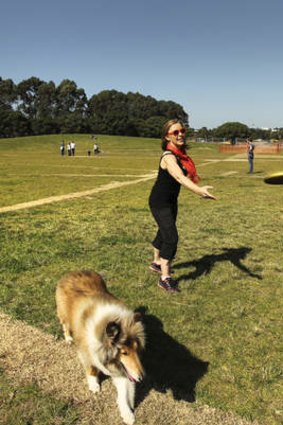 Chantel Lorimer enjoys the early warm weather with her dog Flame at Sydney Park in St Peters.