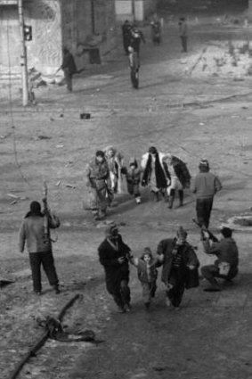 Civilians run for cover during fighting between  Russian troops and Chechen rebels in Grozny, 1994.