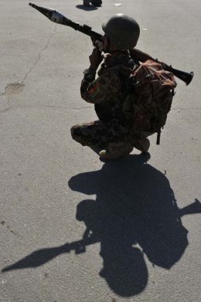Under attack ... an Afghan National Army (ANA) soldier keeps watch near the scene of an attack in Kabul.