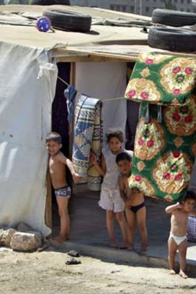 Driven out: Syrian children stand outside their tent at the camp in Faour.