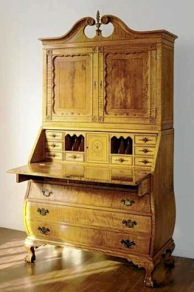 An inlaid maple secretary with a JFK monogram is shown in New York. The mid-20th century Chippendale-style piece sold for $452,000 at auction in 2007.