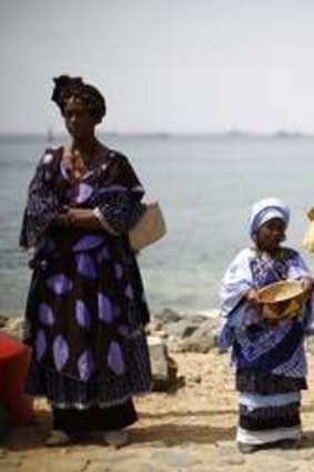 Senegalese women and children in traditional garb await the arrival of President Barack Obama and members of his family at an old slave shipping port - Goree Island near Dakar, Senegal