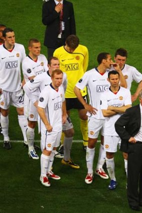 Manchester United players stand dejected after their May 2009 UEFA loss to Barcelona in Rome, Italy.