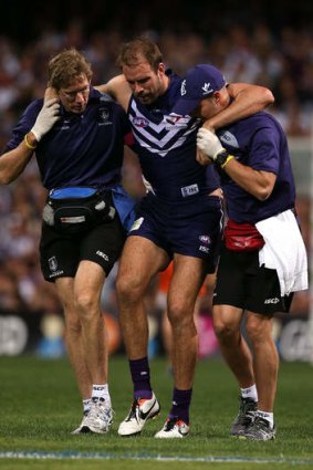 Kepler Bradley of the Dockers is assisted from the field after injuring his right knee.